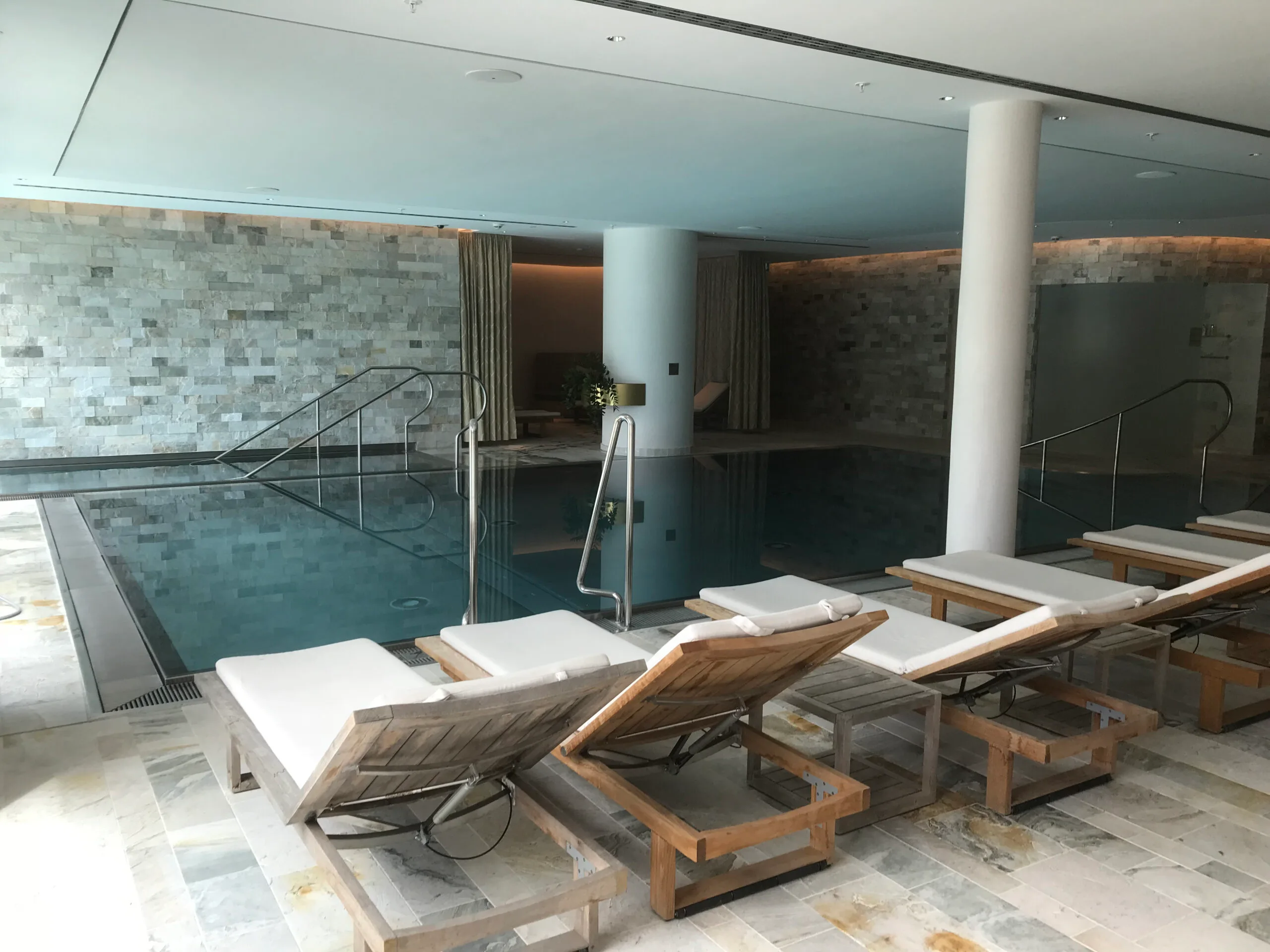 Indoor Pool mit Liegestühlen und Marmorfliesen