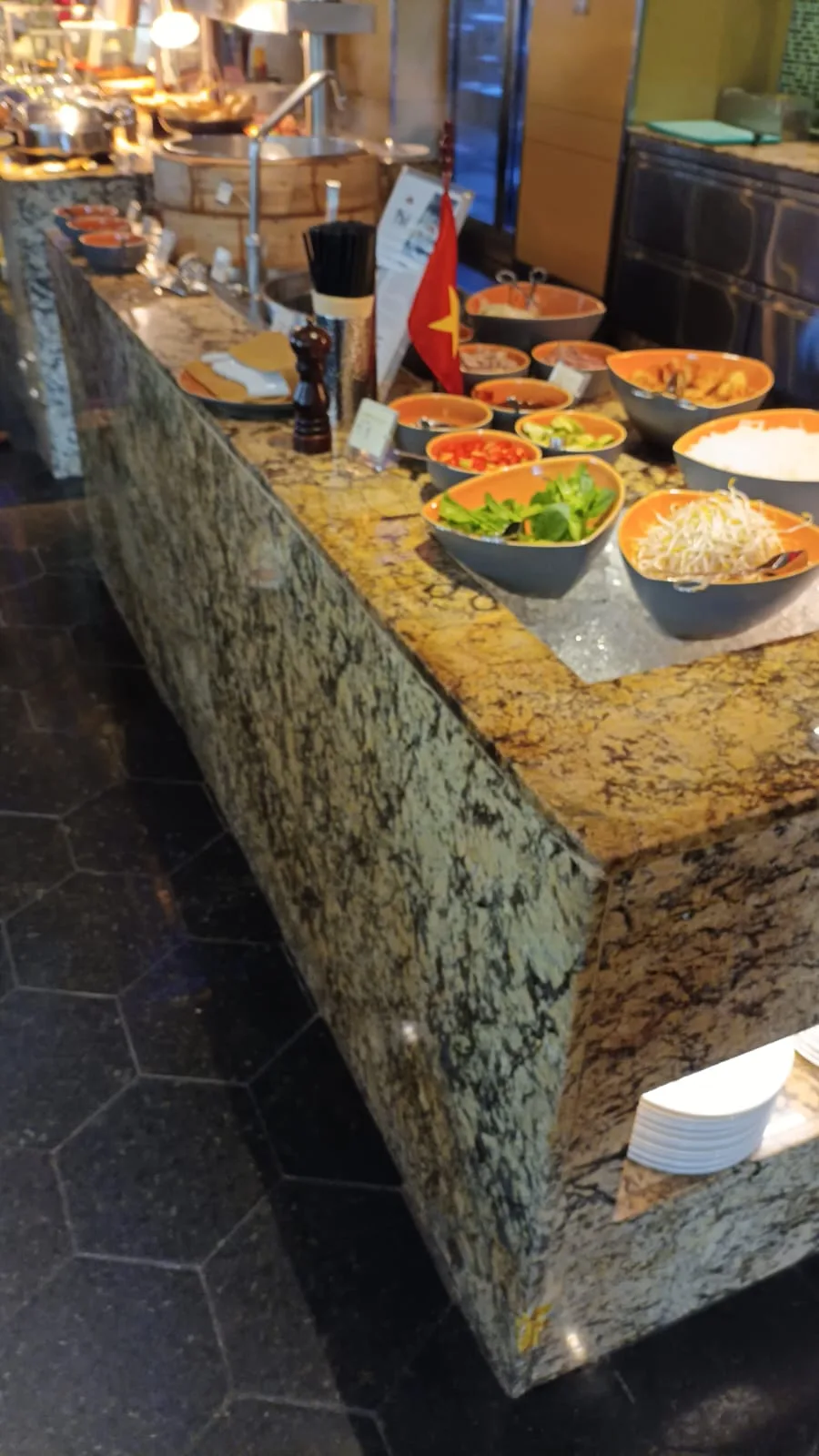Buffet mit verschiedenen Salatsorten und Beilagen auf Granitplatten