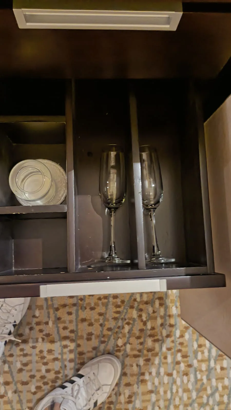 Hotelzimmerschrank mit Gläsern und Tellern