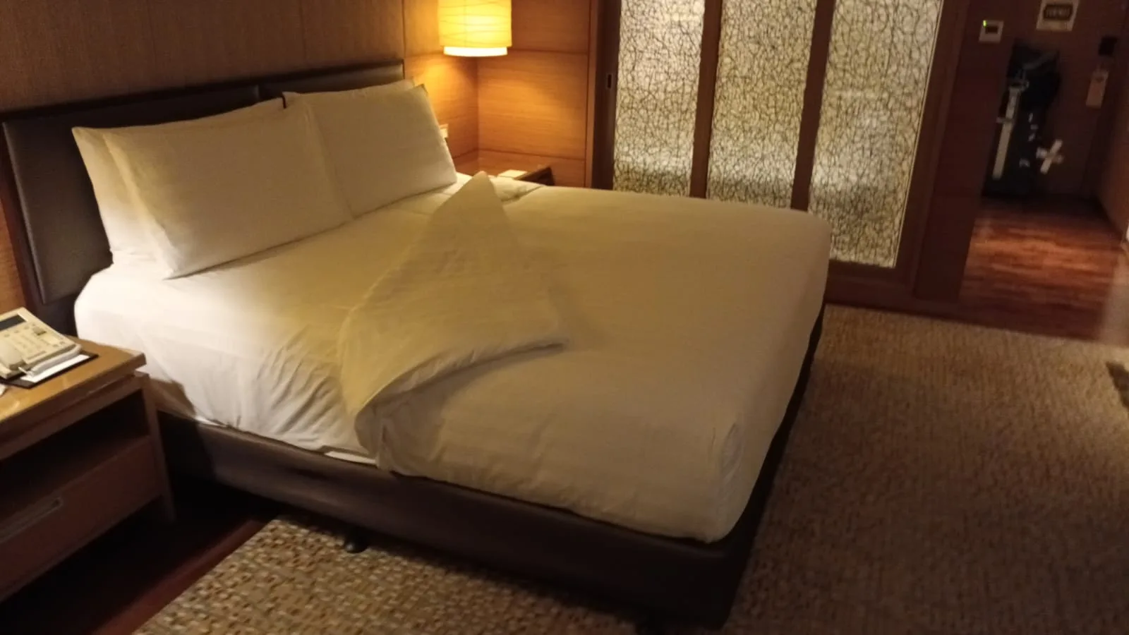 Hotelzimmer mit Doppelbett und Tagesdecke in Grautönen