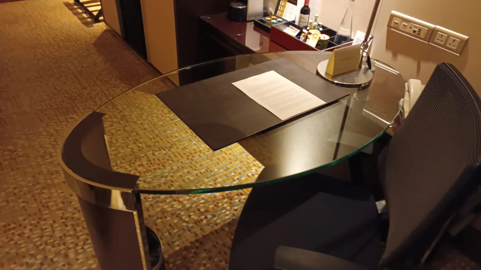 Hotelzimmer mit Glas-Tischplatte und Stuhl