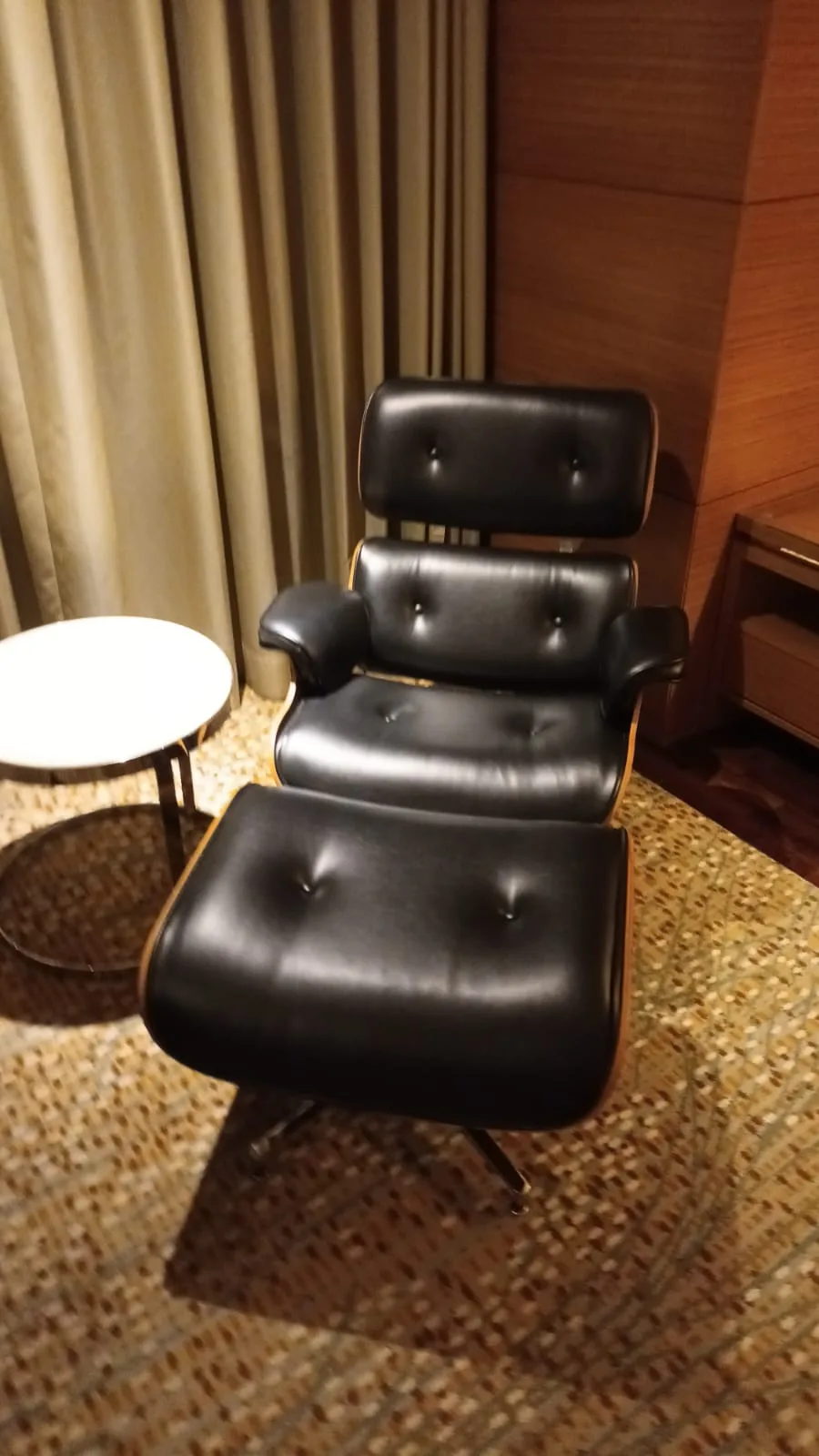 Schwarzer Sessel mit Fußhocker im Hotelzimmer