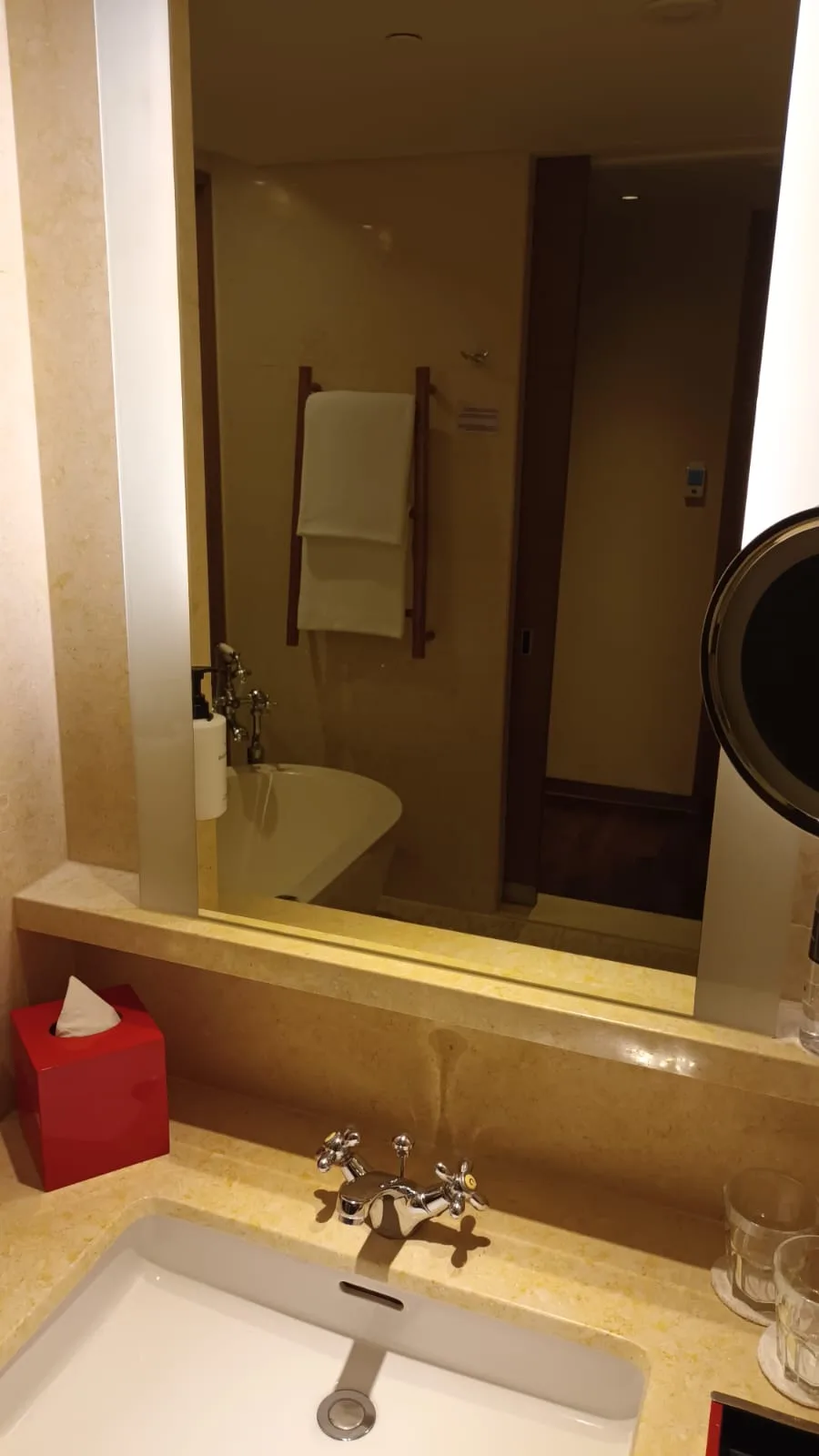 Hotelbadezimmer mit Waschbecken, Spiegel und Handtuchhalter
