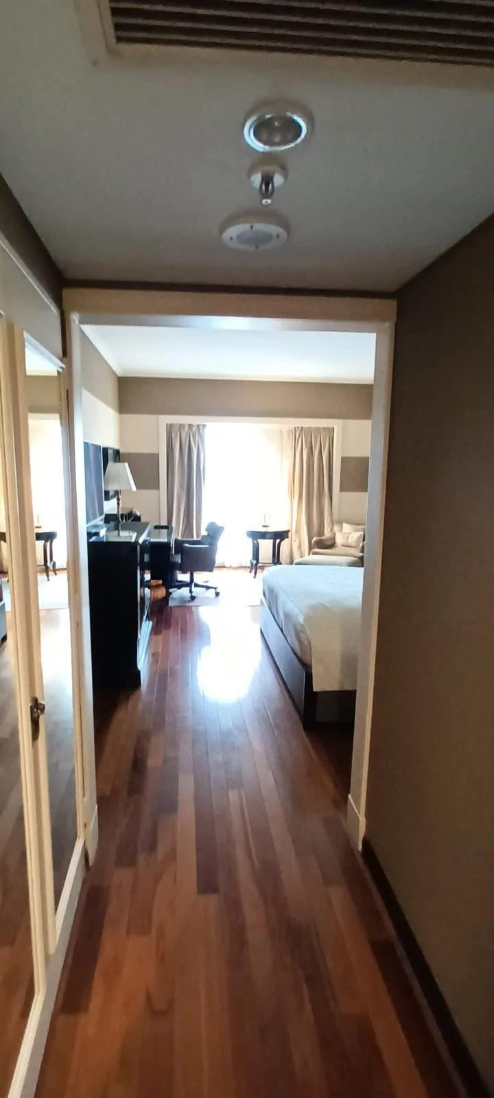 Hotelzimmer mit Doppelbett und Schreibtisch im Flur