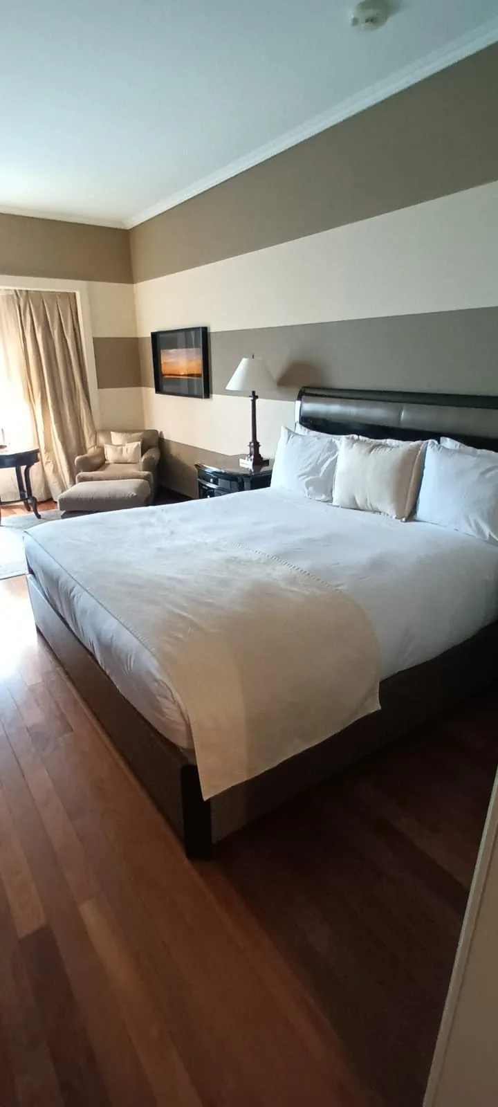 Hotelzimmer mit Doppelbett und Tagesdecke in Grautönen
