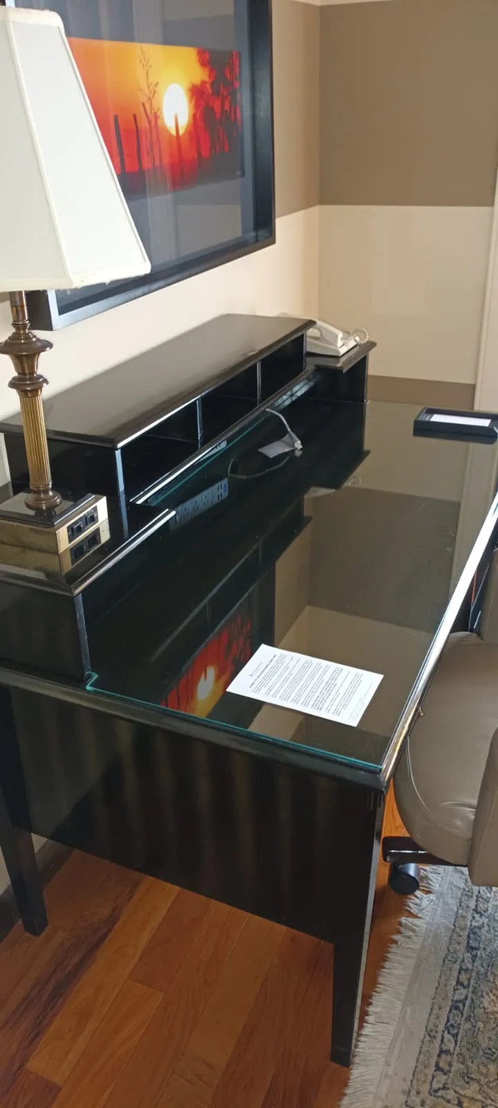 Schwarzer Schreibtisch mit Fernseher und Lampe im Hotelzimmer