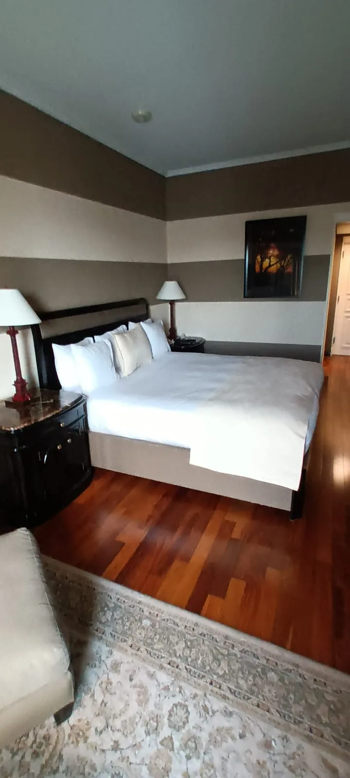 Doppelbett im Hotelzimmer mit Holzboden und Teppich