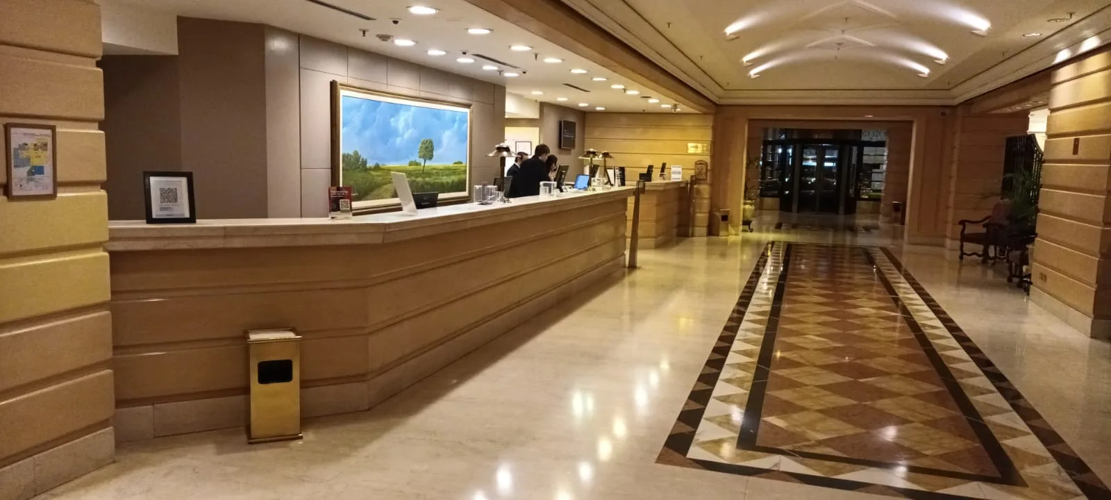 Rezeption eines Hotels mit Marmorflächen und Wandbild