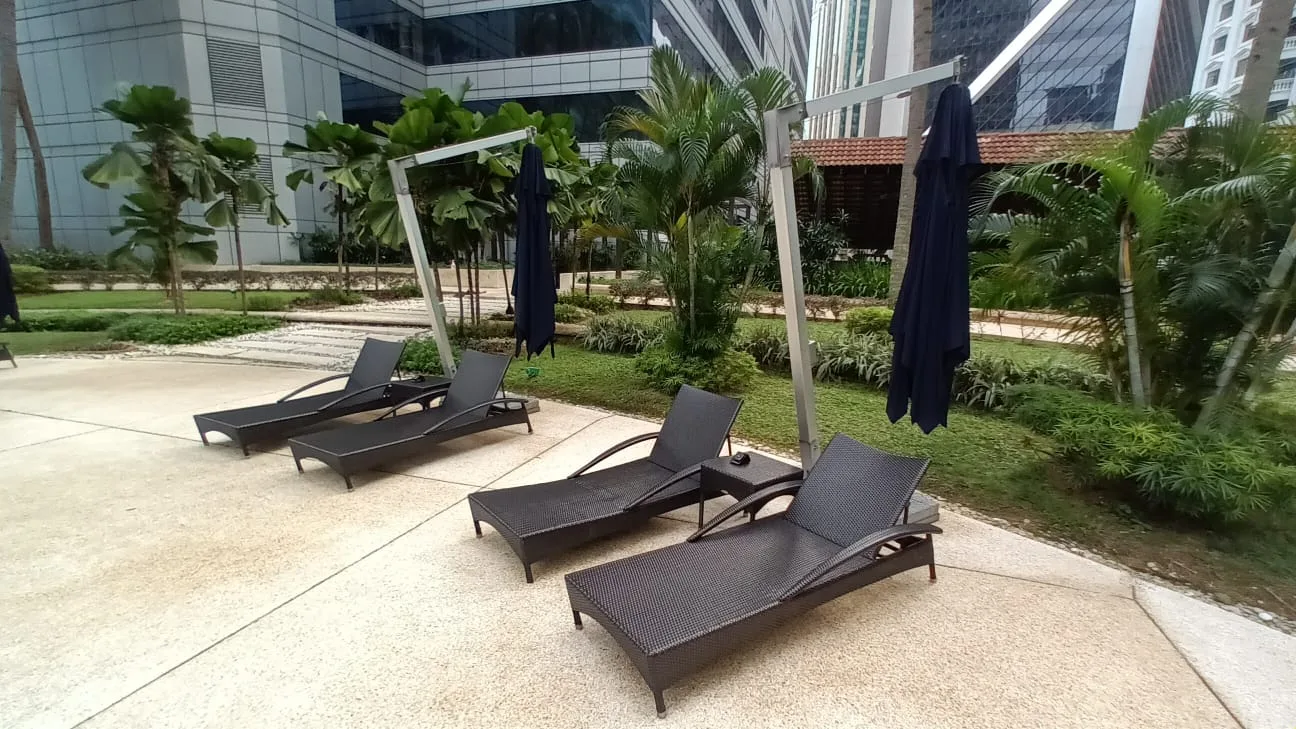 Lounge-Stühle mit Sonnenschirmen im Garten eines Hotels