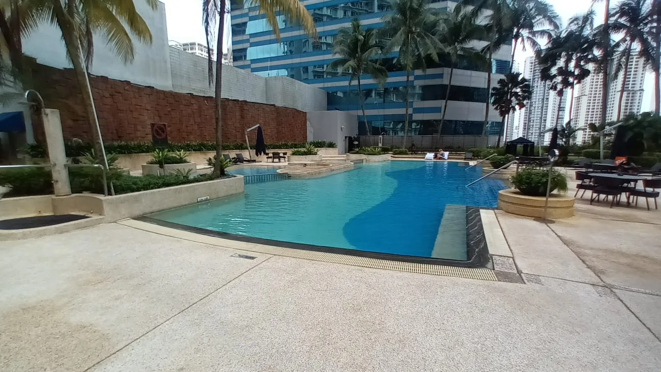 Außenbereich eines Hotels mit Pool und Palmen