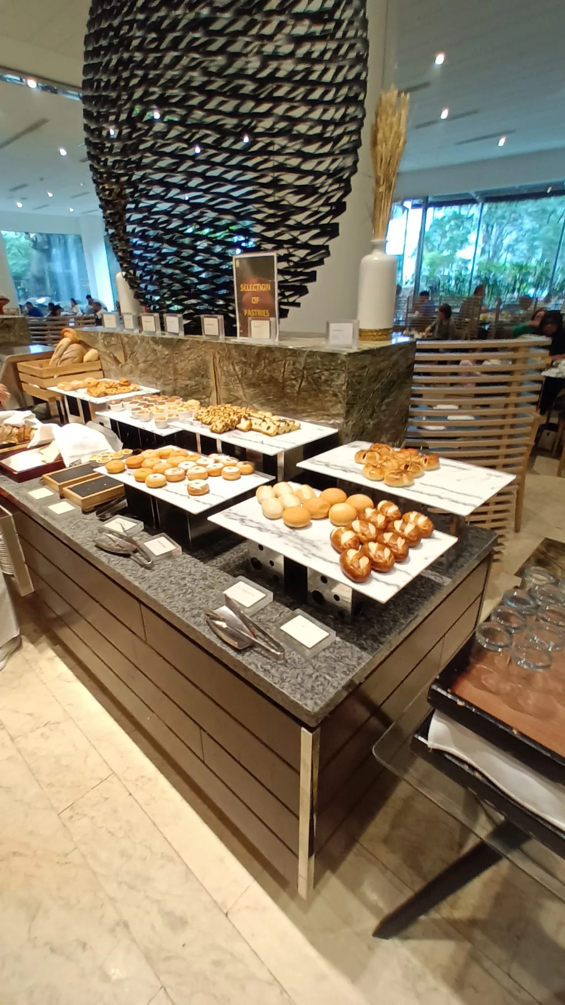 Frühstückstheke mit verschiedenen Gebäcksorten und Kaffee auf Marmortisch