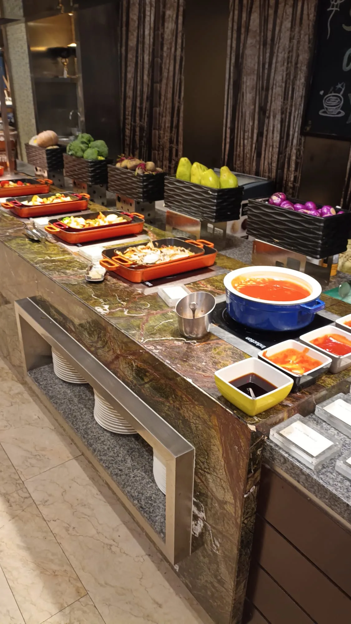 Frühstücksbuffet mit verschiedenen Gerichten und Suppe auf Marmorplatte