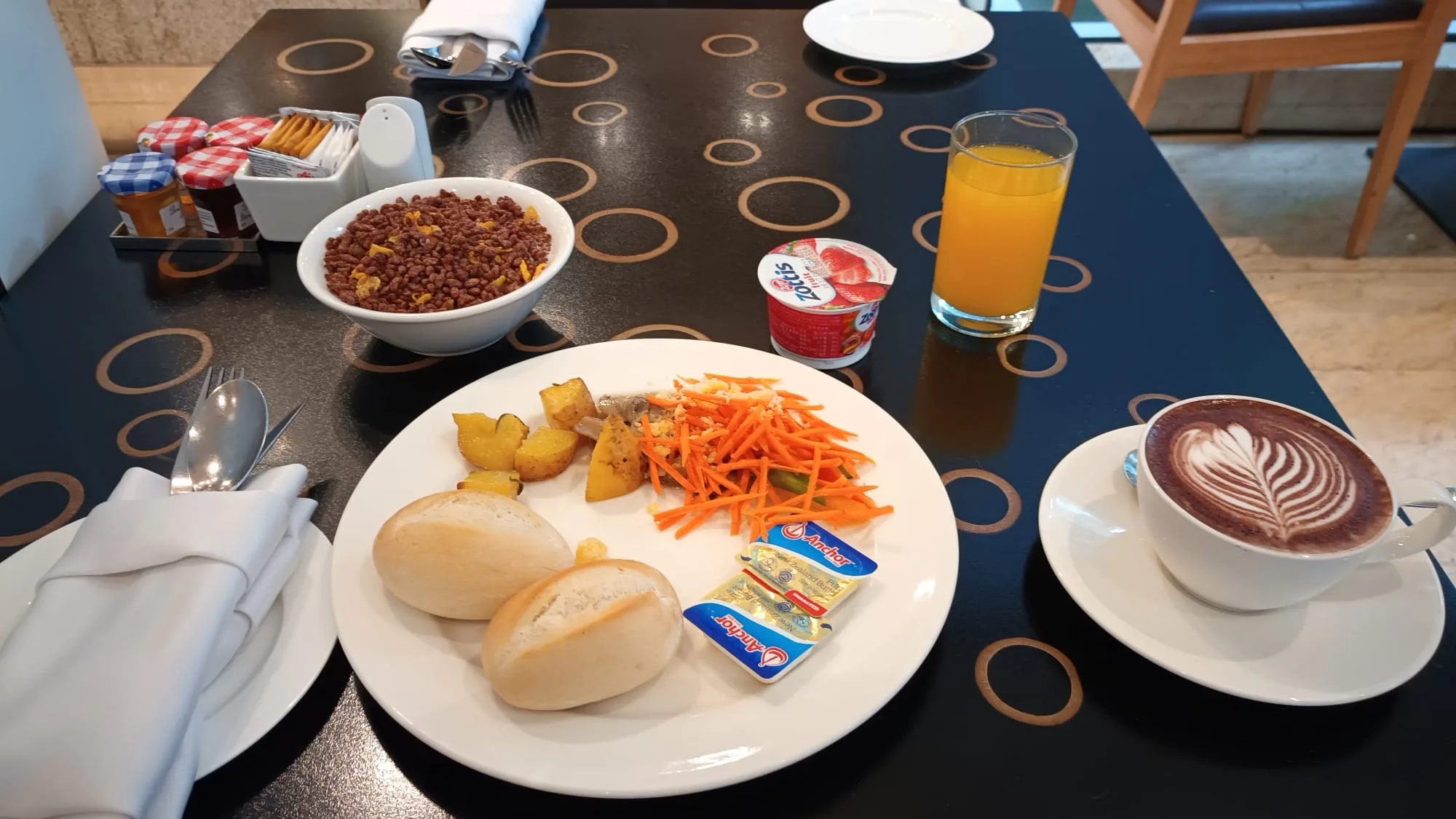 Frühstückstablett mit Kaffee, Obstsalat, Brot und Orangensaft