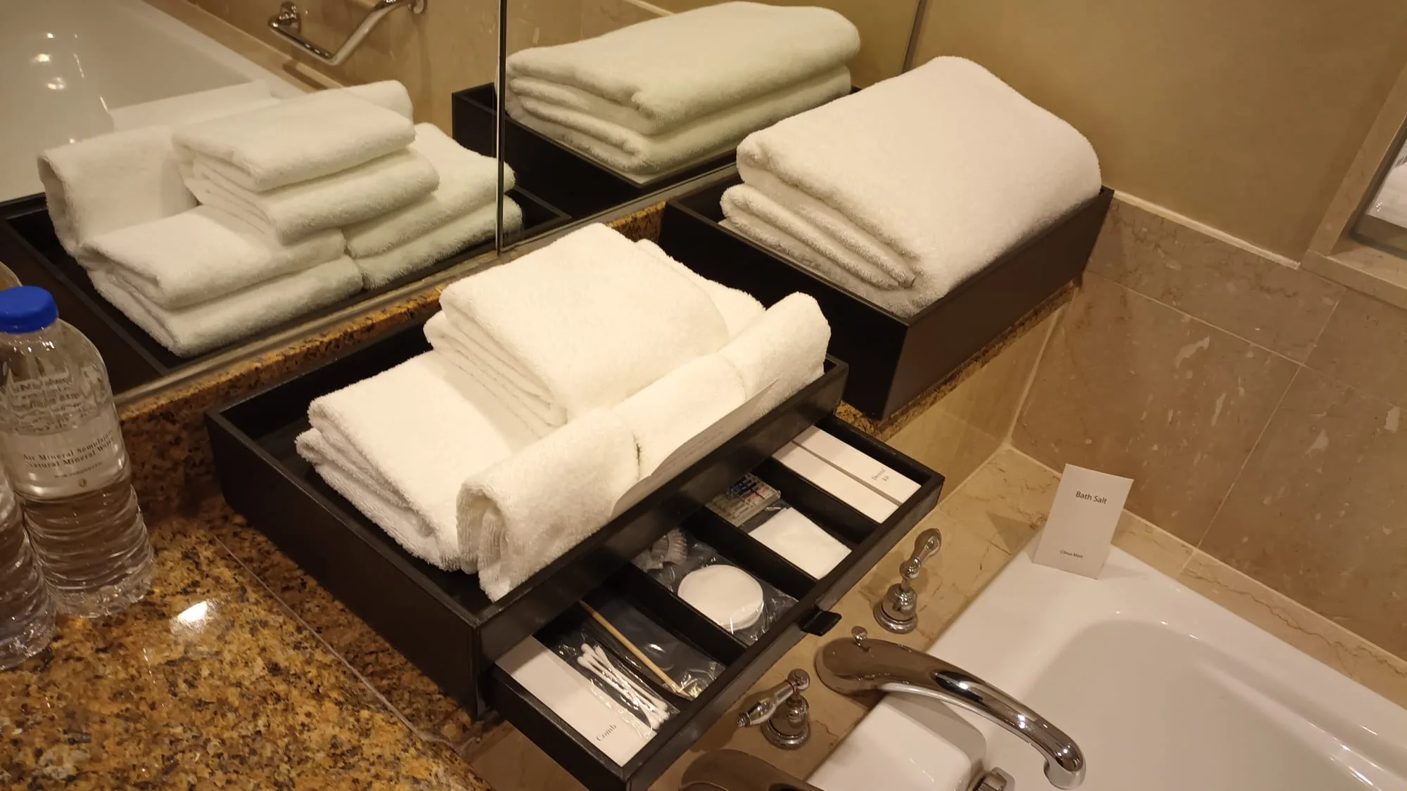 Hotelbad mit Handtüchern und Kosmetikartikeln auf Regal