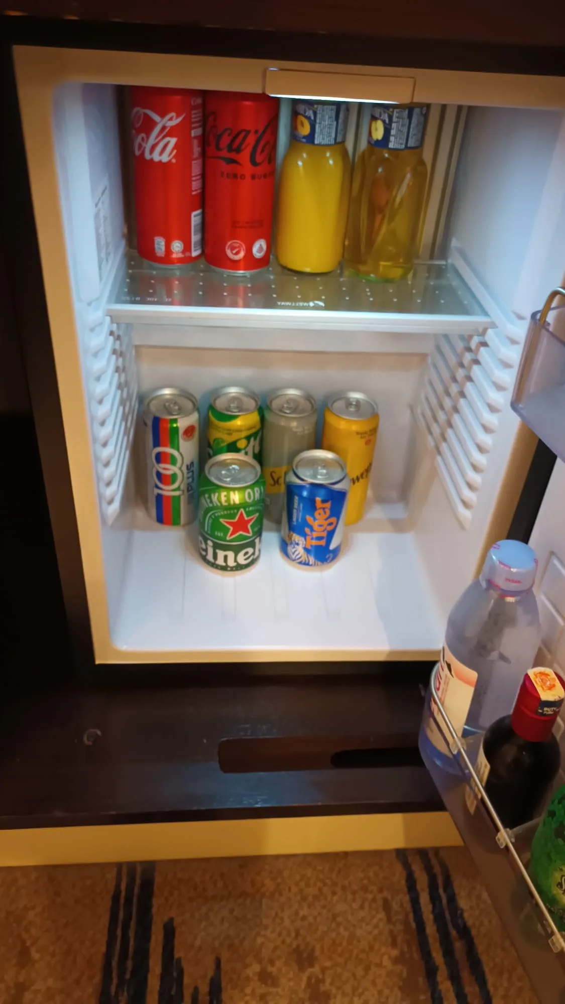 Hotelkühlschrank mit Getränken wie Coca-Cola, Orangensaft und Bier