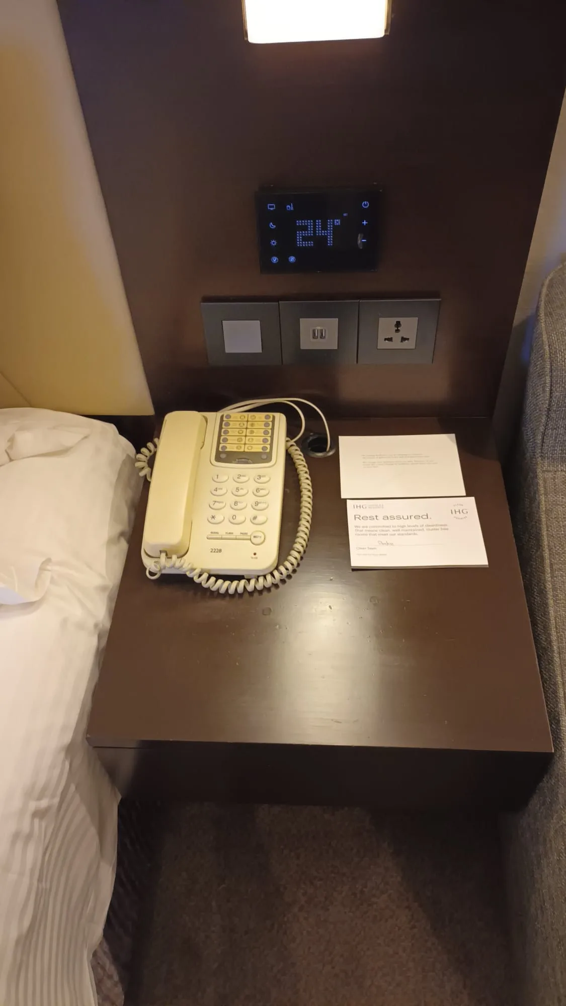 Hotelnachttisch mit Telefon, Temperaturanzeige und Notizkarte