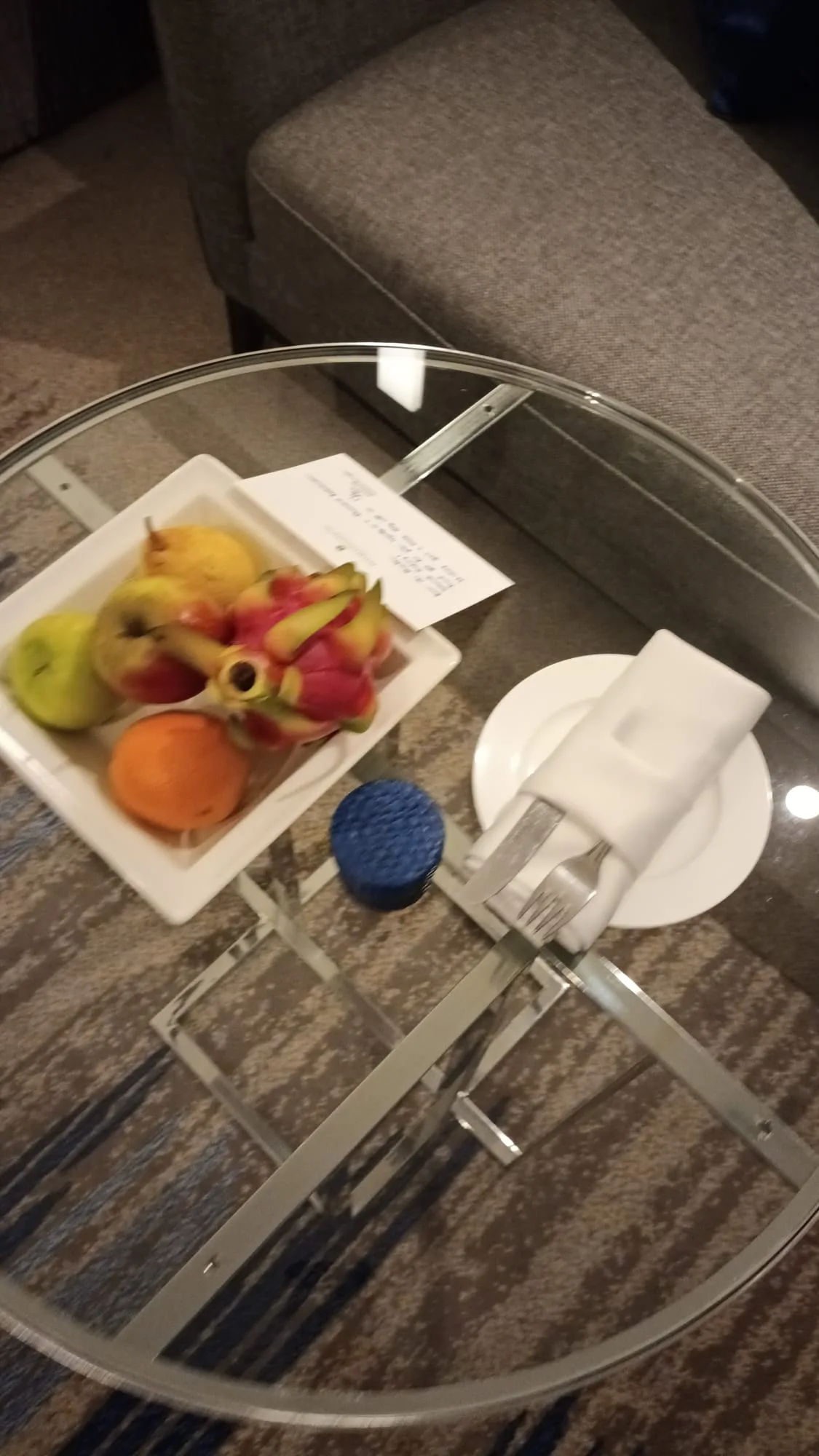 Glasplatte mit Obstschale und Serviette auf Couchtisch