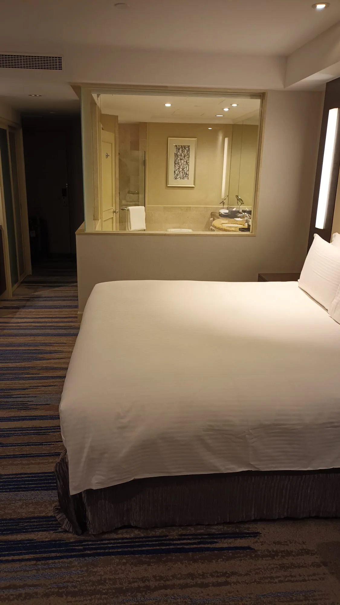 Hotelzimmer mit Doppelbett und Badezimmer im Hintergrund