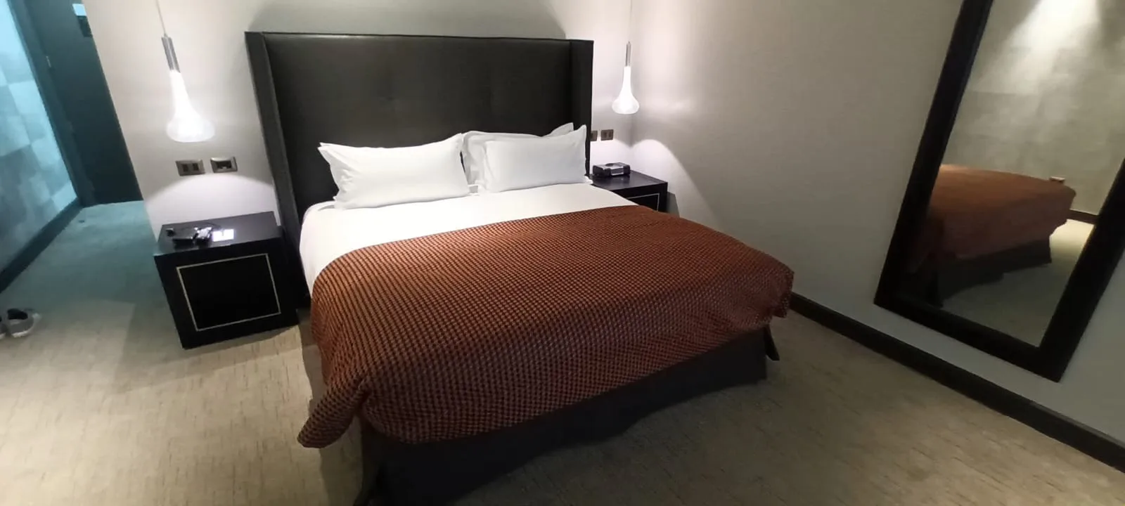 Hotelzimmer mit Doppelbett und rotem Überwurf