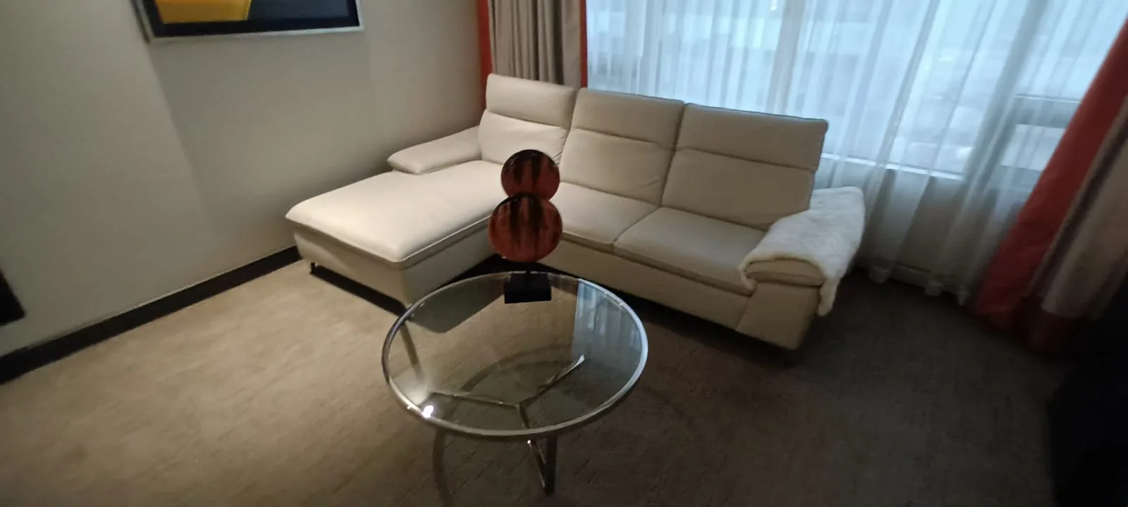 Weißes Sofa mit Couchtisch und moderner Dekoration im Hotelzimmer