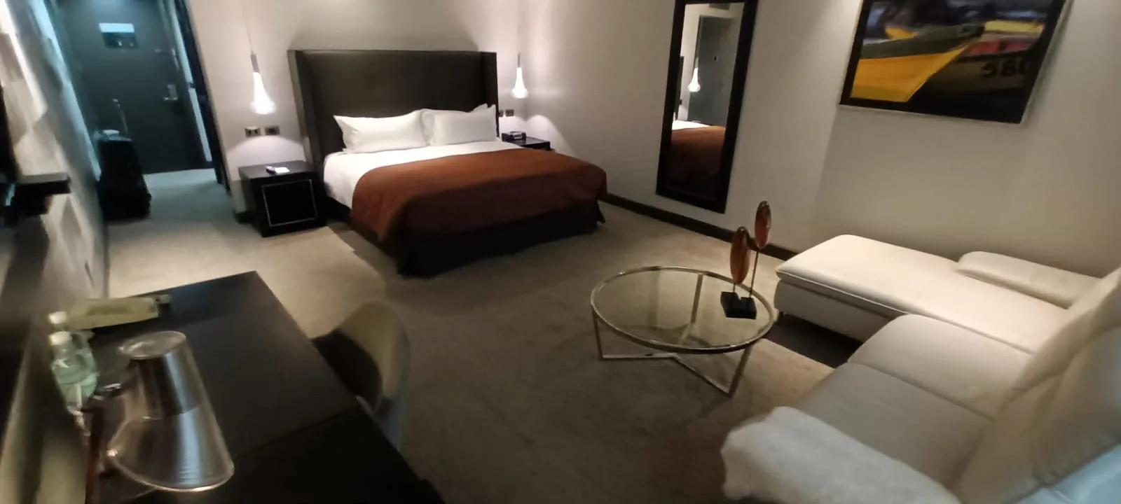 Hotelzimmer mit Doppelbett und Couch in Grautönen