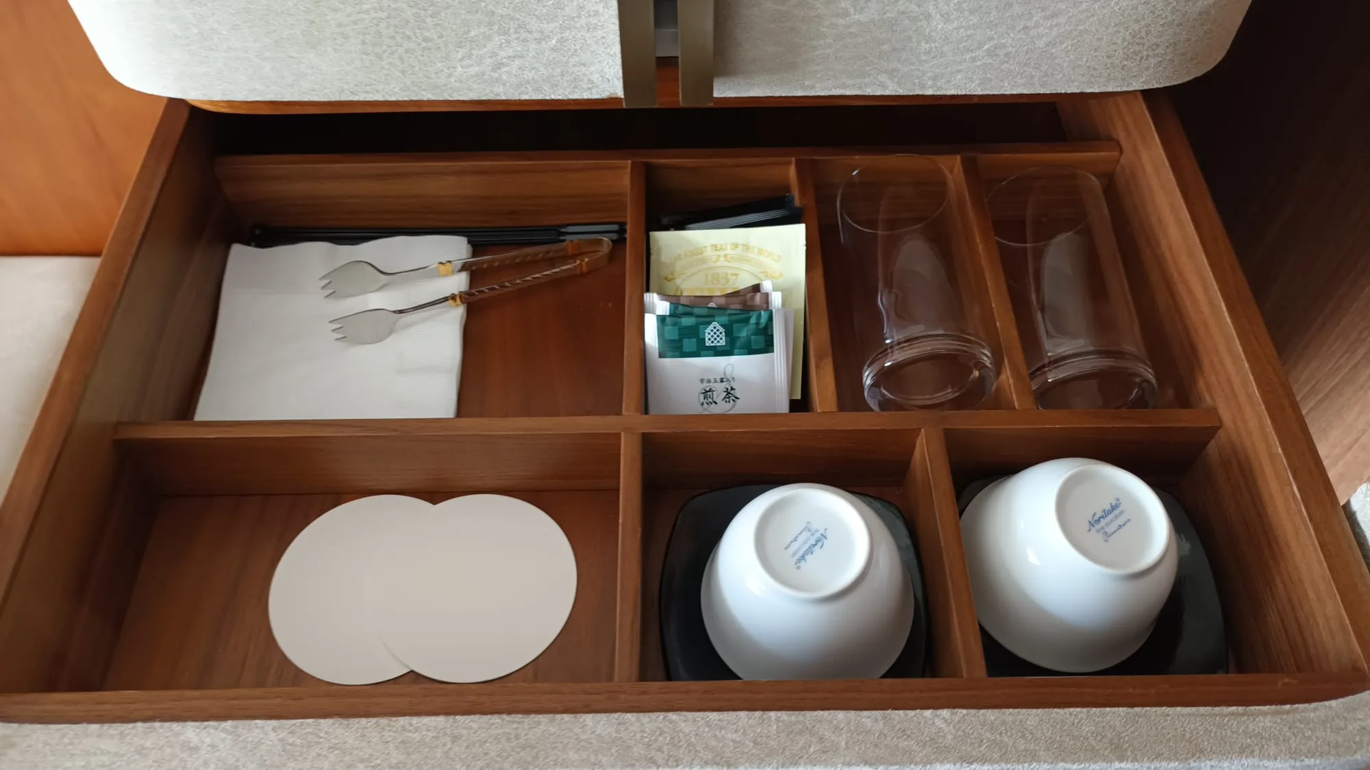 Organisierte Schublade mit Besteck, Teetassen und Untersetzer