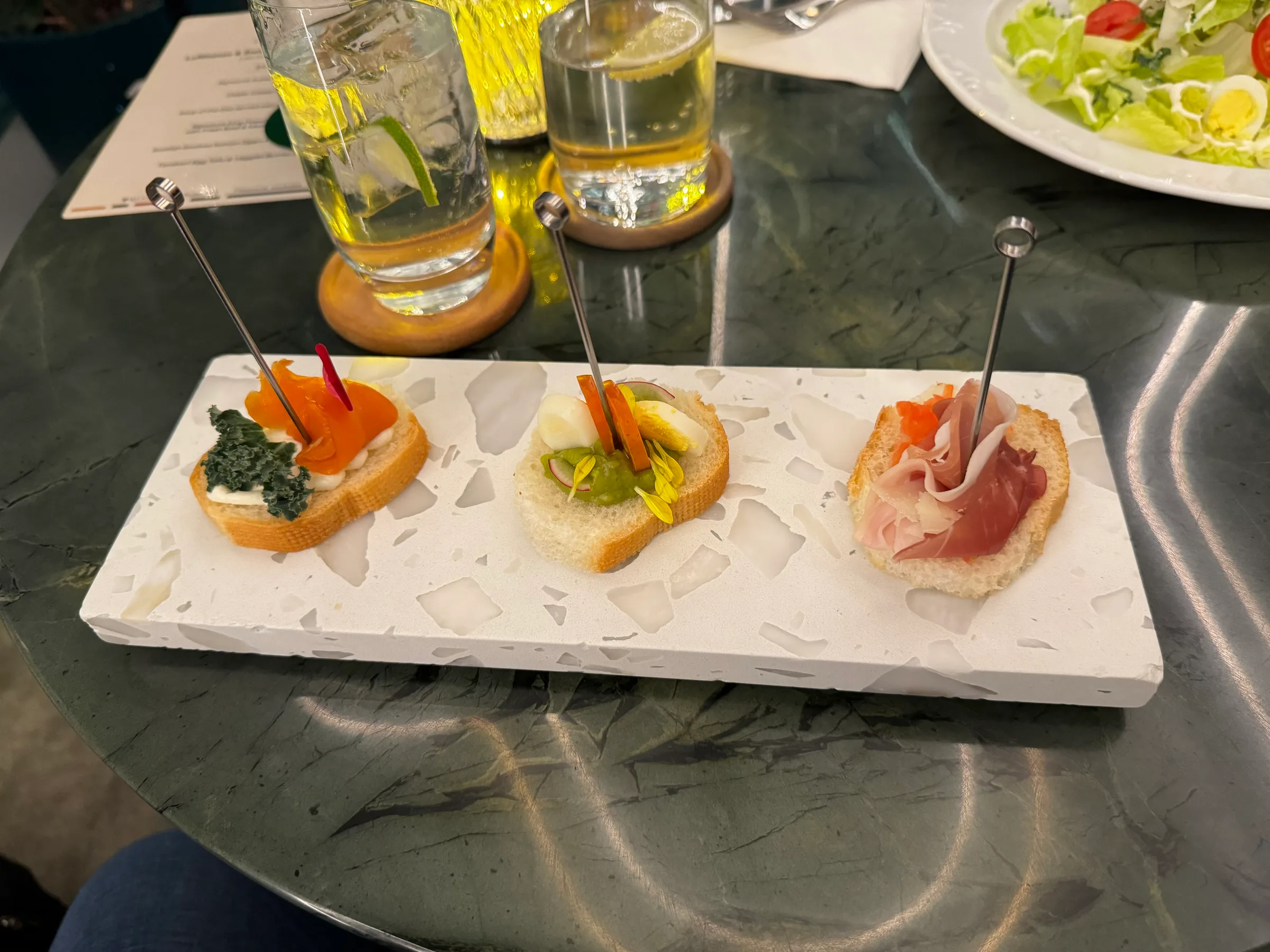 Drei Canapés auf einem weißen Tablett mit Metallstäben