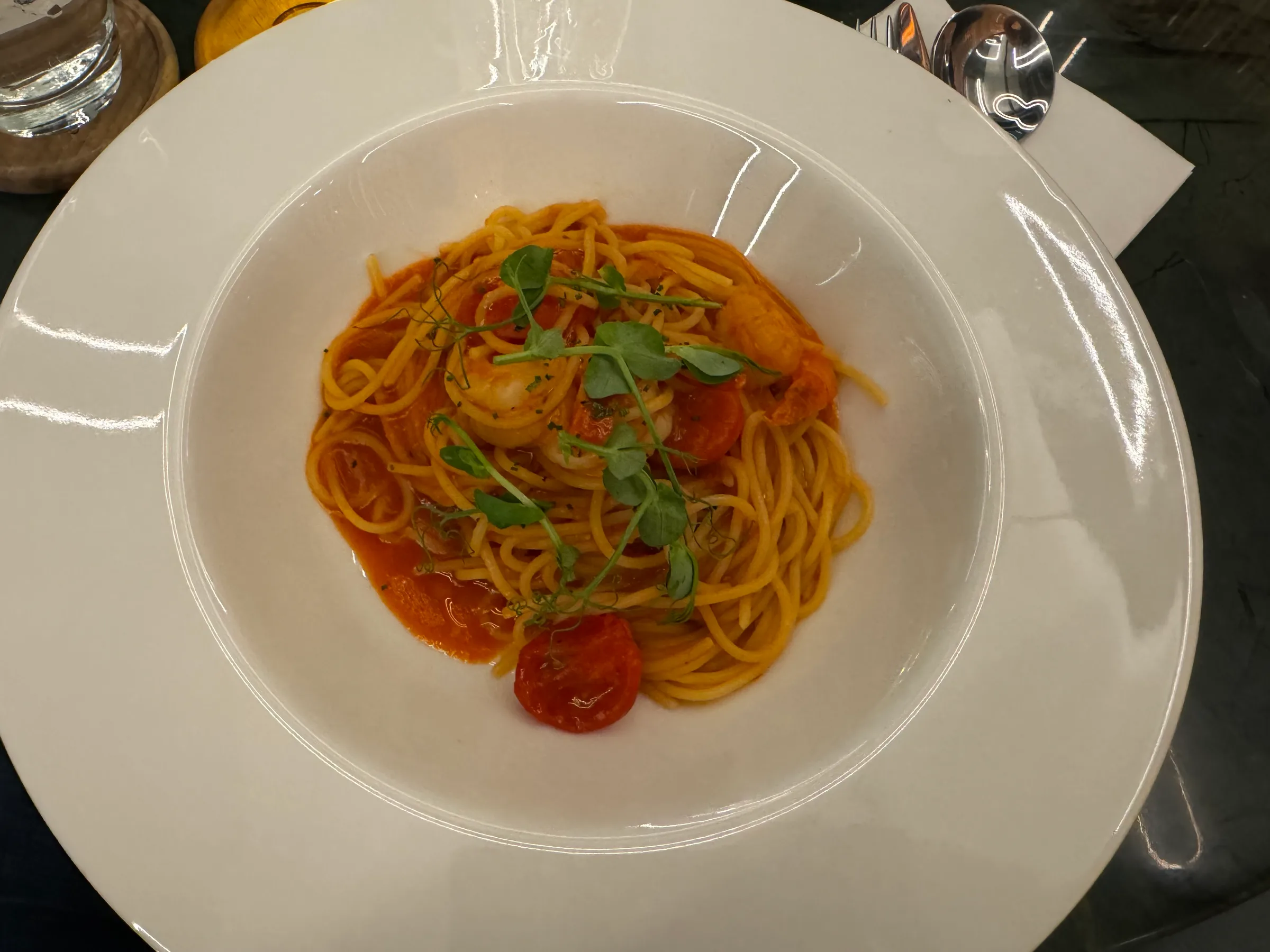 Spaghetti mit Garnelen und Tomatensoße auf weißem Teller