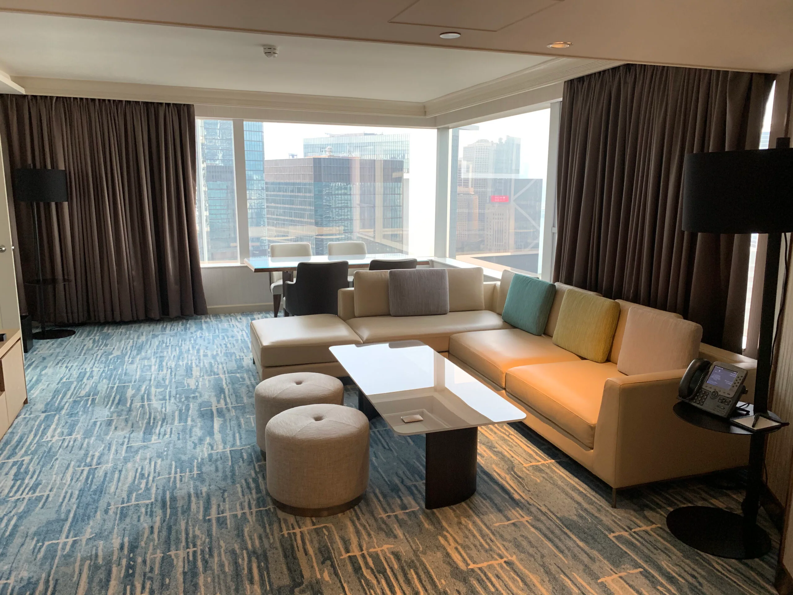Hotelzimmer mit Couch und Sitzgelegenheiten in Pastellfarben