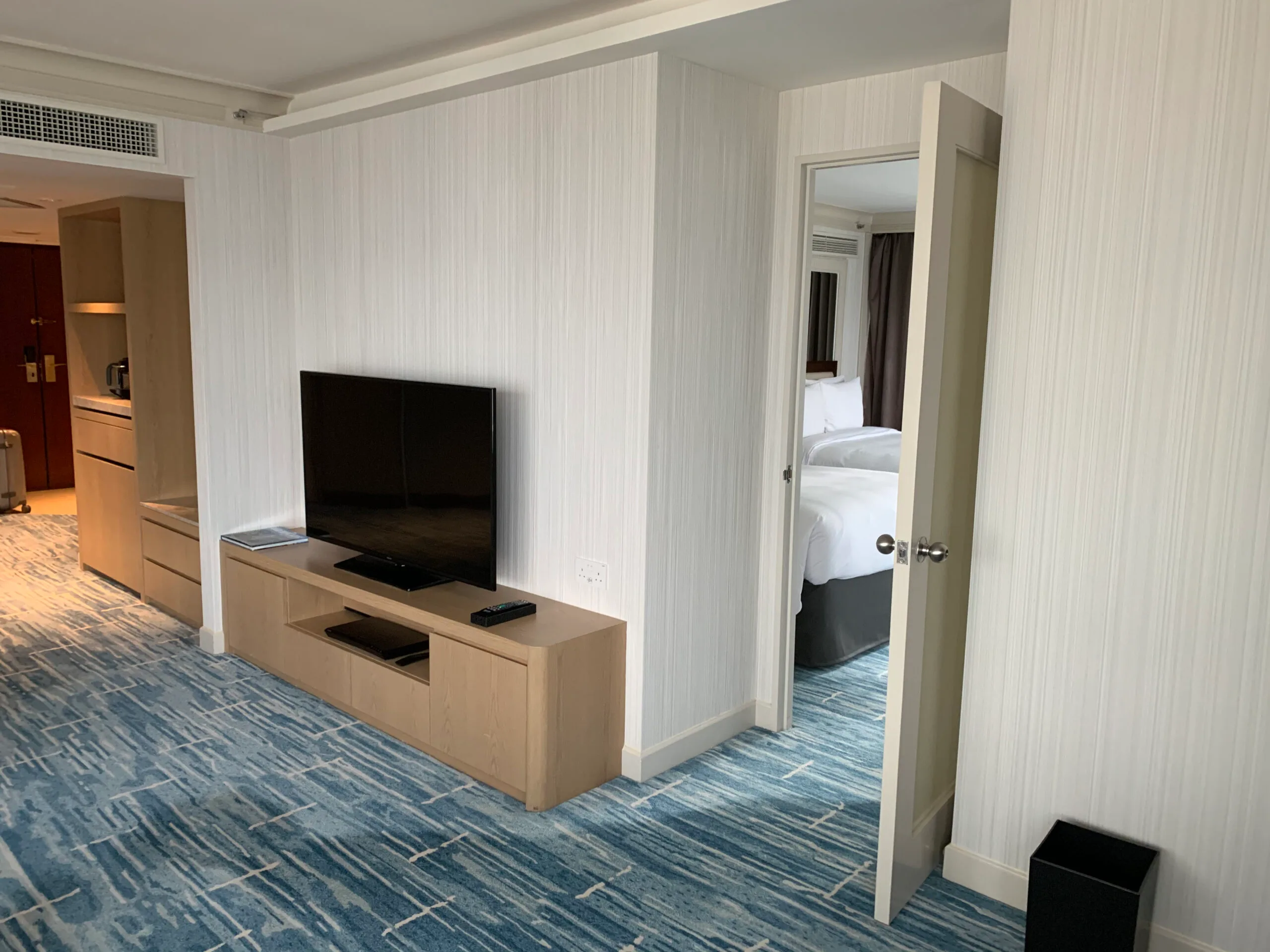 Hotelzimmer mit Flachbildfernseher und Holzregal