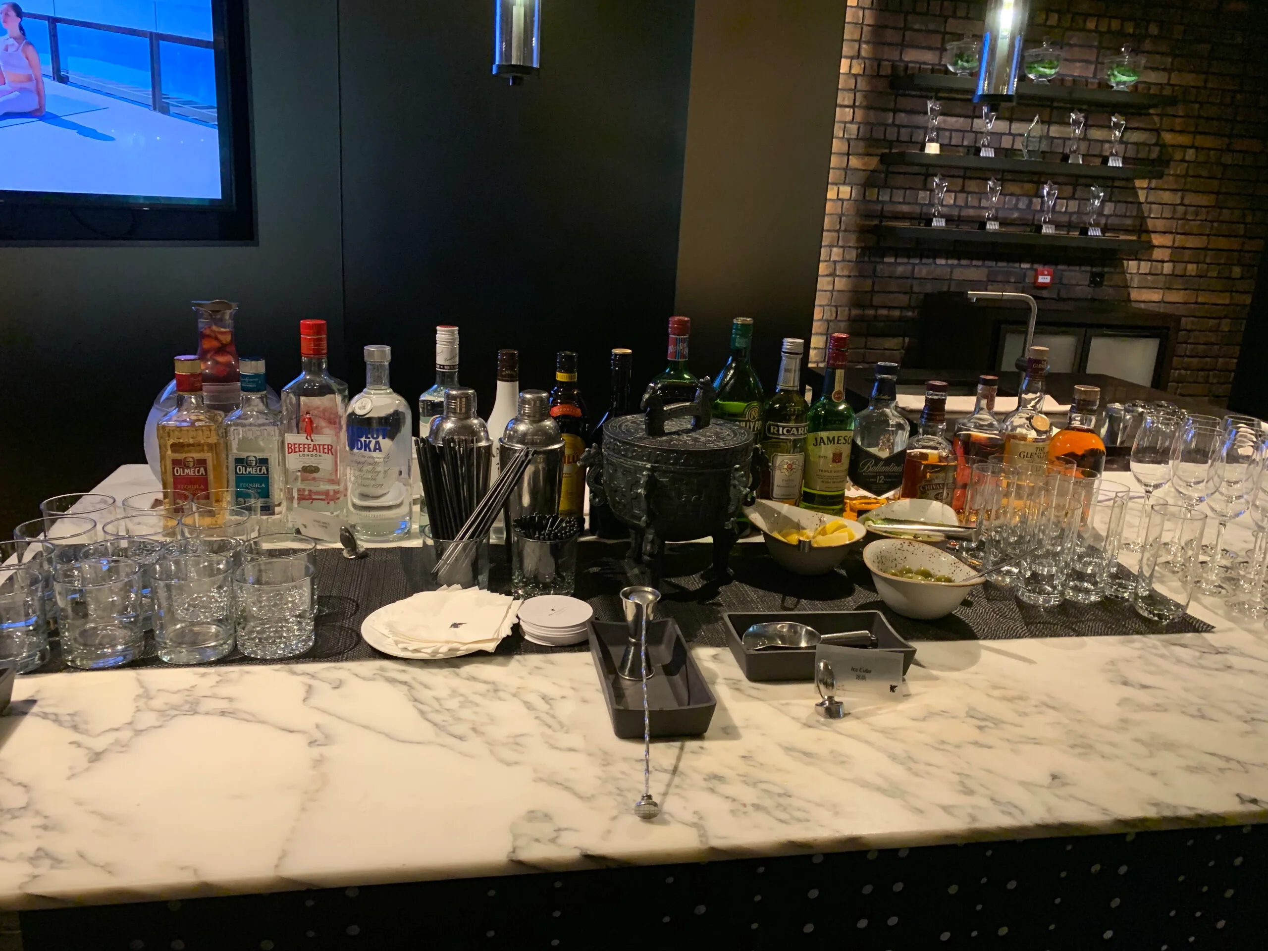 Bar mit verschiedenen Flaschen und Gläsern auf Marmorplatte