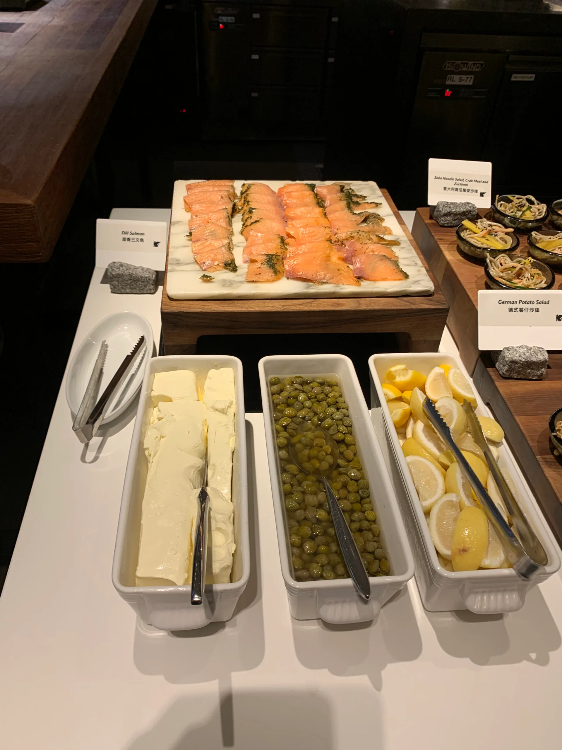 Salmon-Schnittchen auf Marmorplatte mit Butter, Oliven und Zitronen