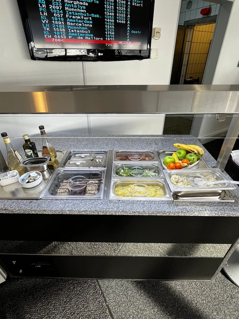 Frühstücksbuffet mit Obst, Salaten und Getränken im Loungebereich