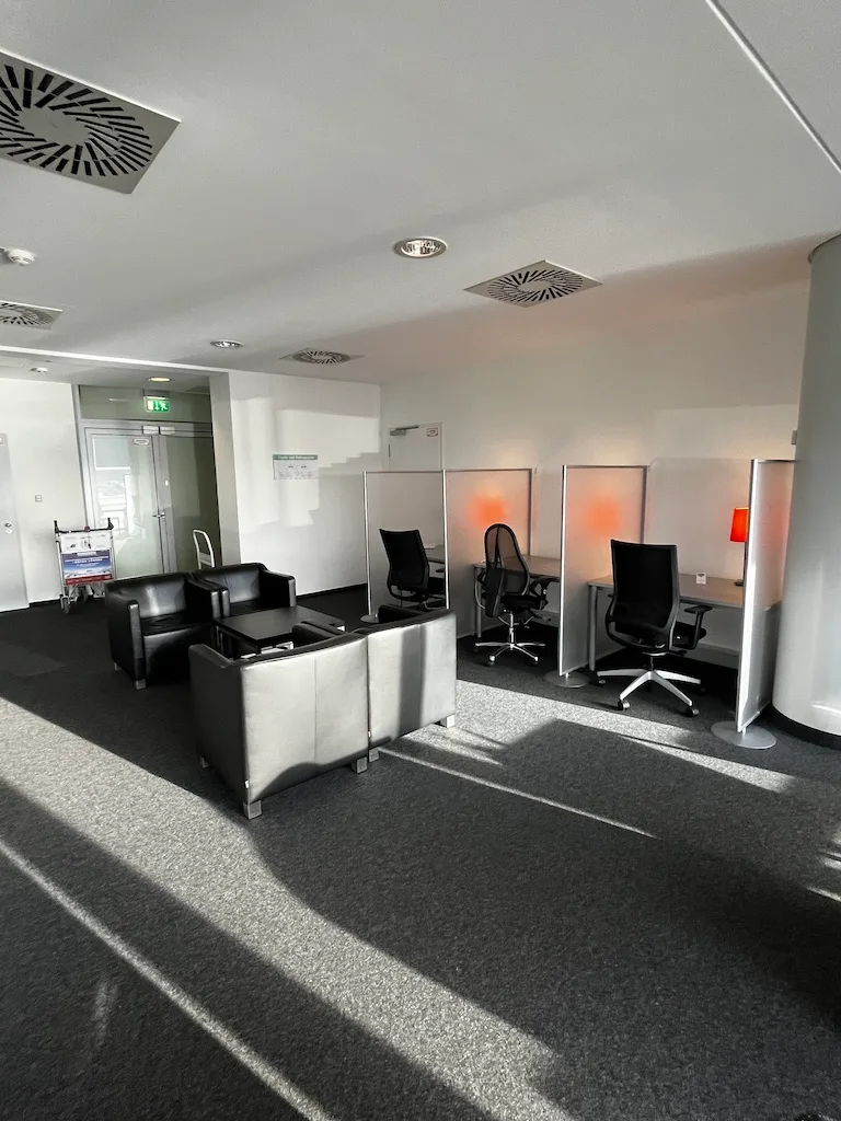 Kleiner Flughafen-Lounge mit Sesseln und Arbeitsplätzen