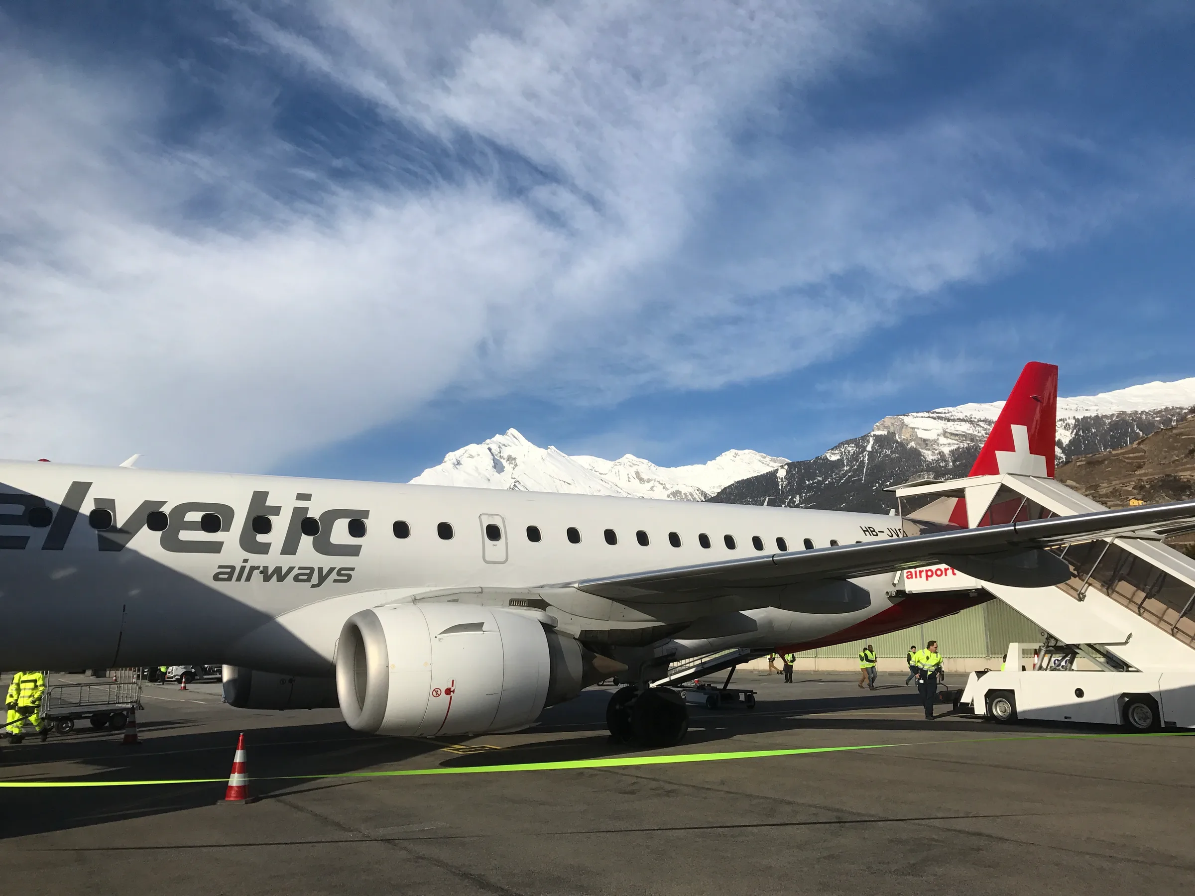 Helvetic-Airways-Flugzeug mit schneebedeckten Bergen