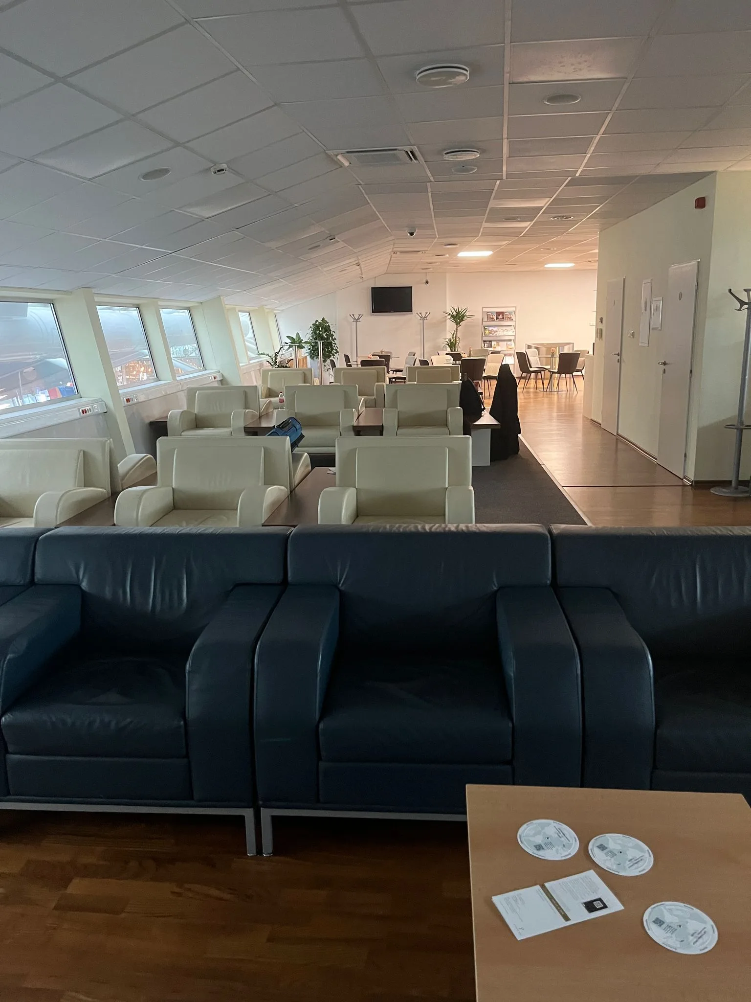 Business Lounge mit Sitzmöbeln und Fensterfronten