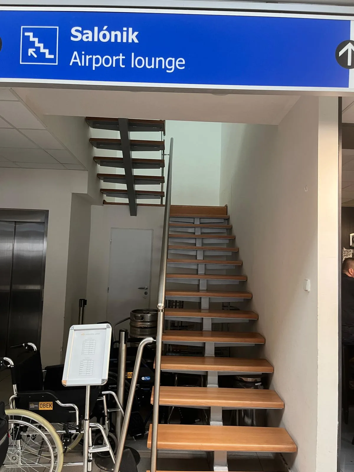 Treppe zum Flughafenlounge mit Schild 'Salónik Airport lounge'