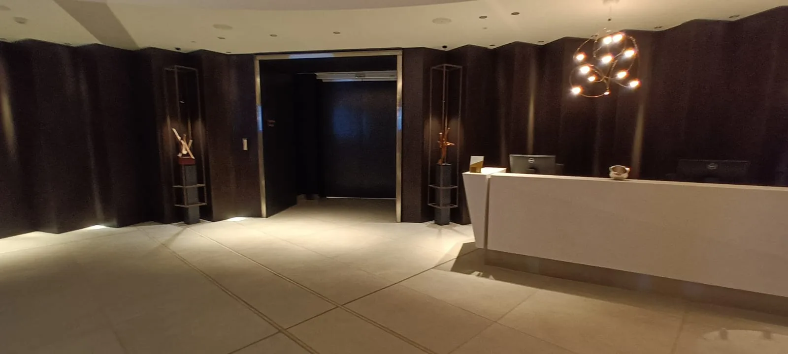 Rezeption in einem Luxushotel mit dunklen Wänden und moderner Beleuchtung