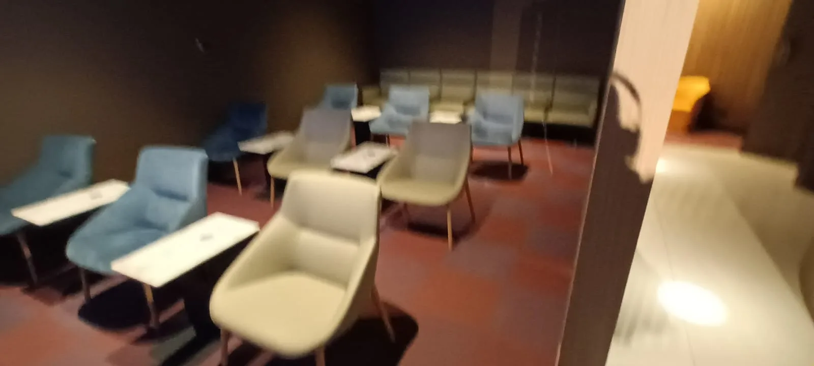 Lounge mit blauen und grauen Stühlen und Tischen