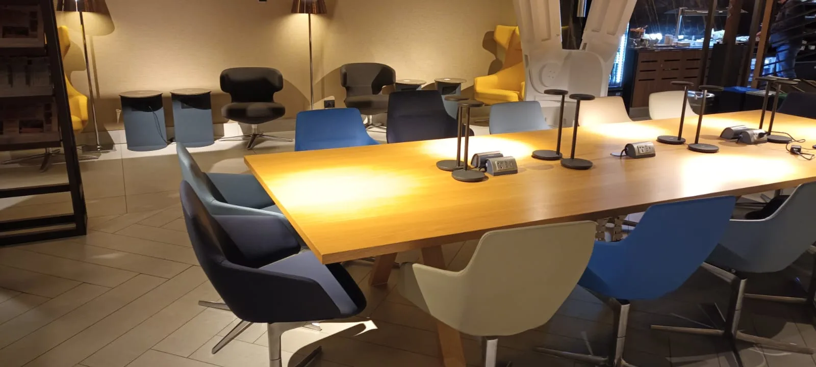 Lounge mit Holztisch und bunten Stühlen