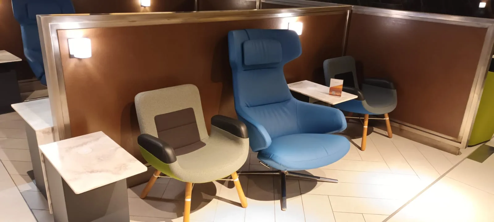 Lounge mit blauen Sesseln und Holztischen