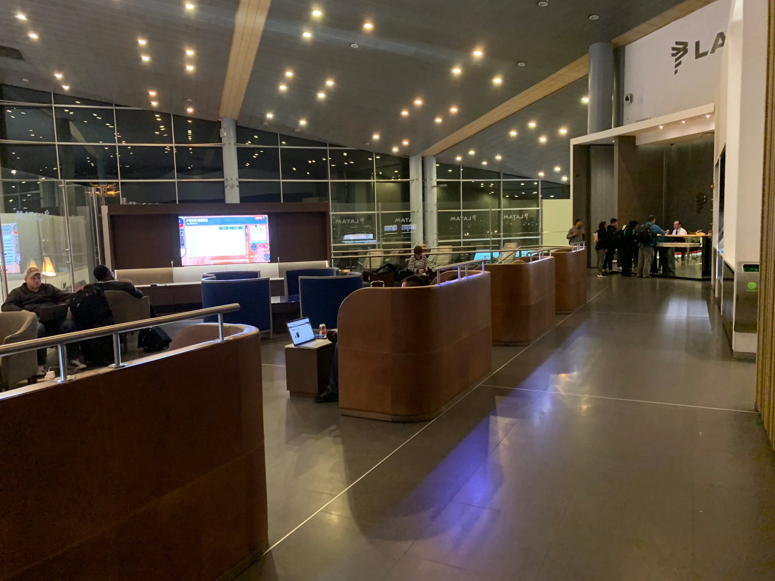VIP-Lounge mit Holztresen und Stühlen vor Fenstern