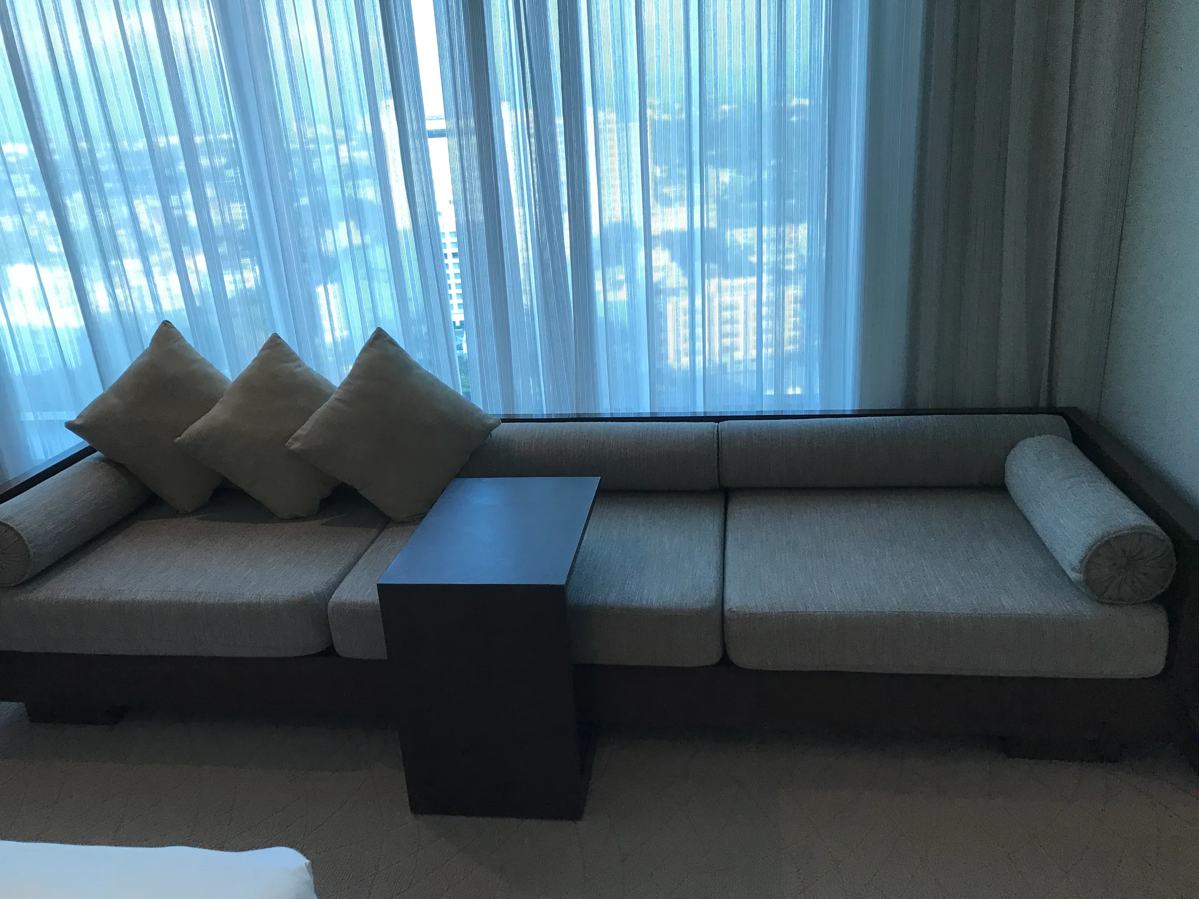 Hotelsofa mit Kissen vor großem Fenster