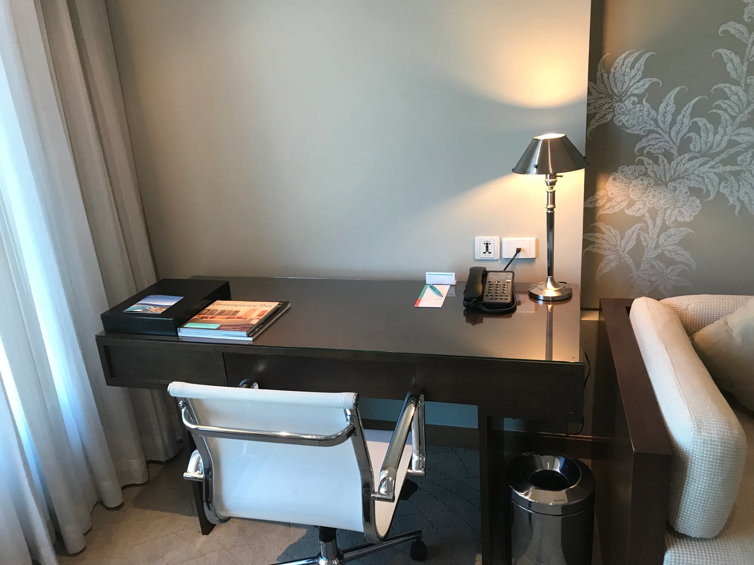Hotelzimmer mit Schreibtisch, Stuhl und Lampe