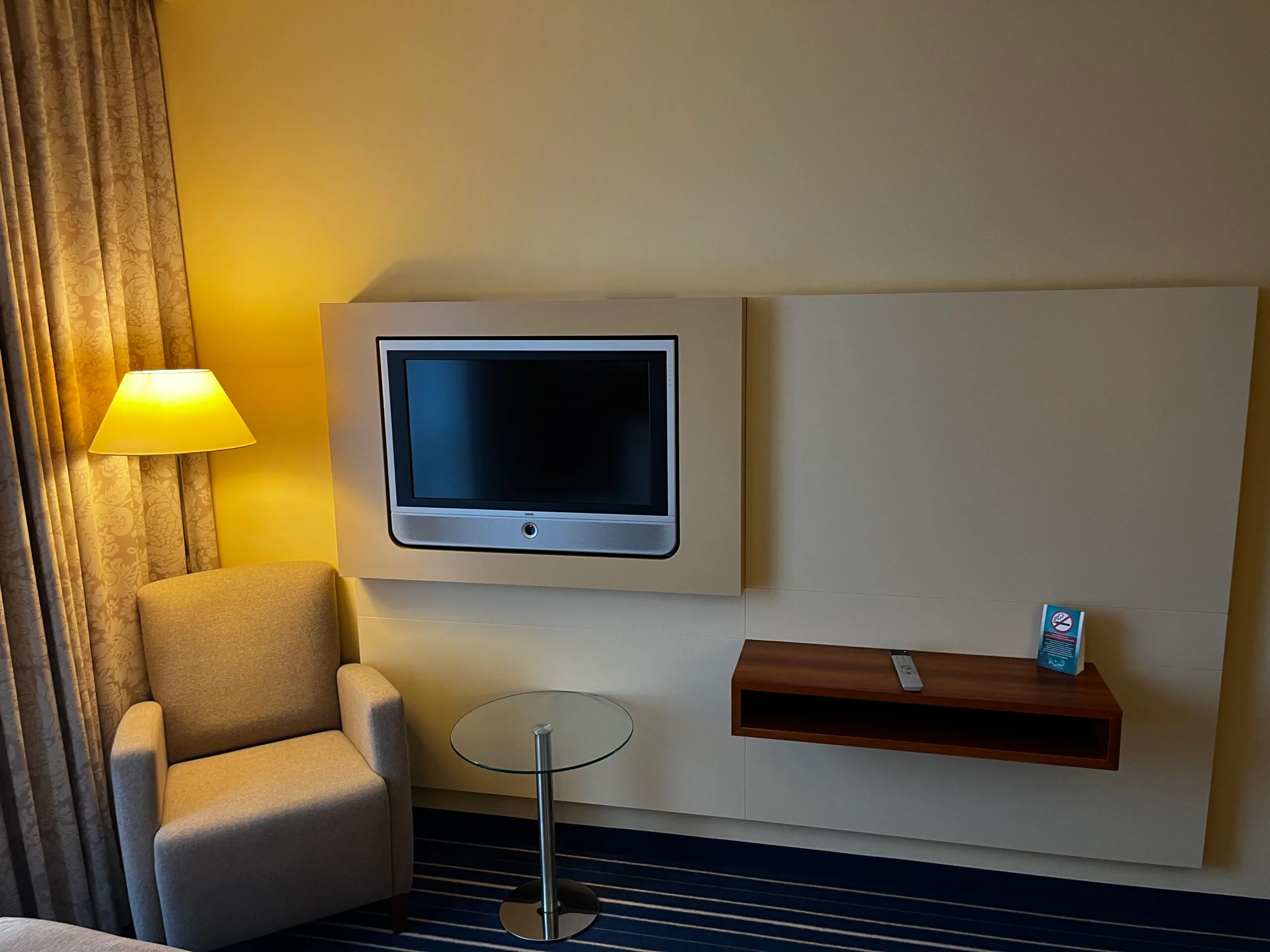Hotelzimmer mit Flachbildfernseher und Sessel