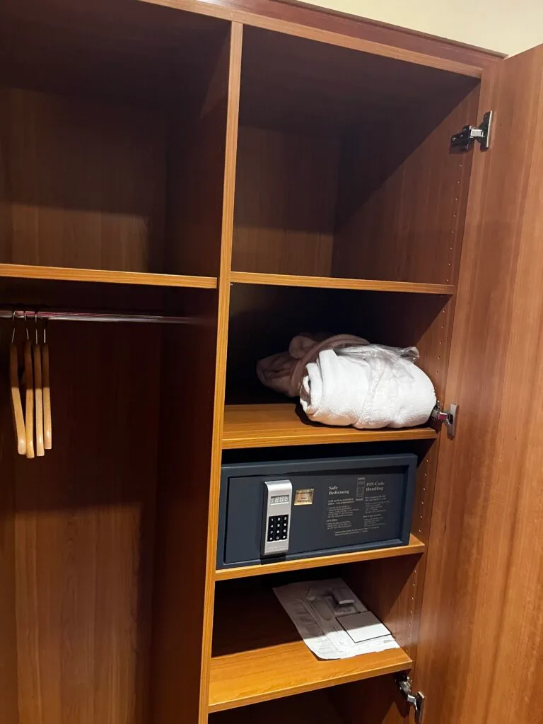 Hotelgarderobe mit Kleiderbügeln und Safe