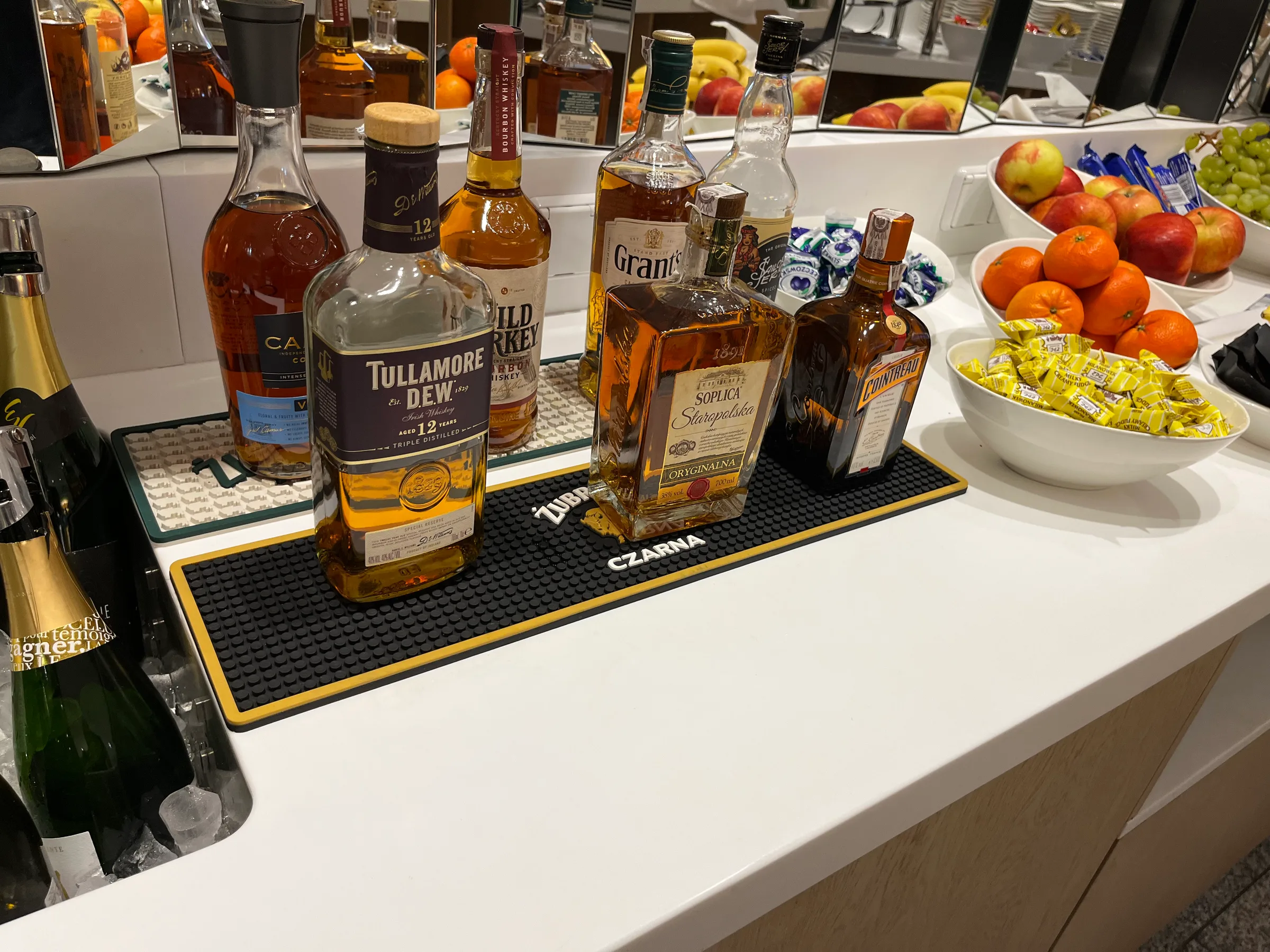Bar mit Flaschen von Tullamore Dew und anderen Spirituosen sowie Obstschalen
