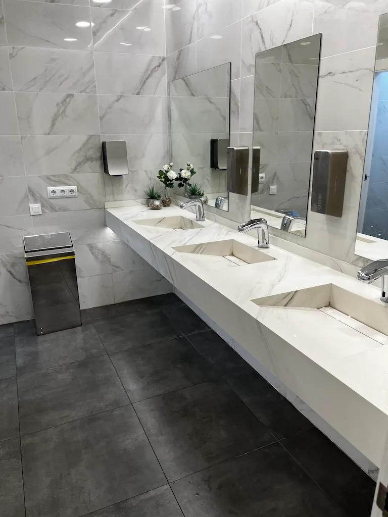 Modernes Waschbecken mit Spiegeln und Handtuchautomaten in einem Flughafensalon