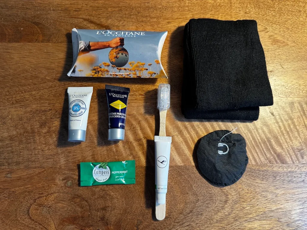Inhalt ausgebreitet — L'Occitane, Zahnbürste und Socken