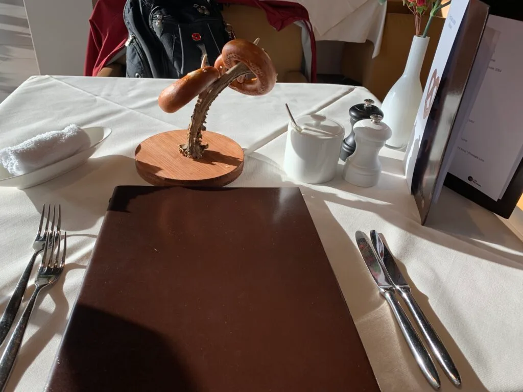 Lounge-Tisch mit Bagel und Besteck auf weißem Tuch
